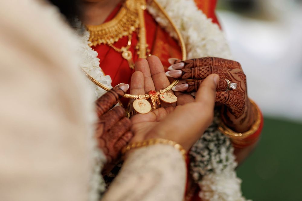 Close-up view of traditional Indian wedding attire showing intricate henna designs and jewelry details.