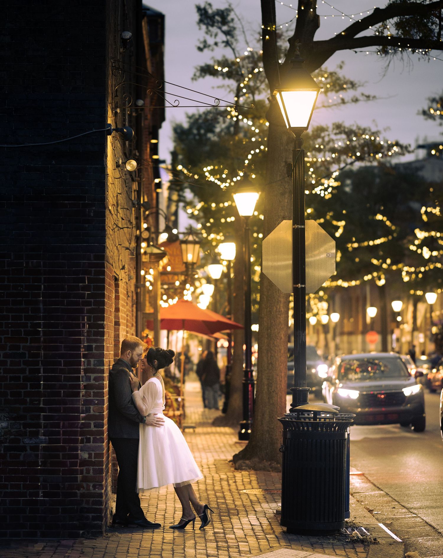 Evening street scene with glowing lanterns and cobblestone sidewalk in Old Town Alexandria.
