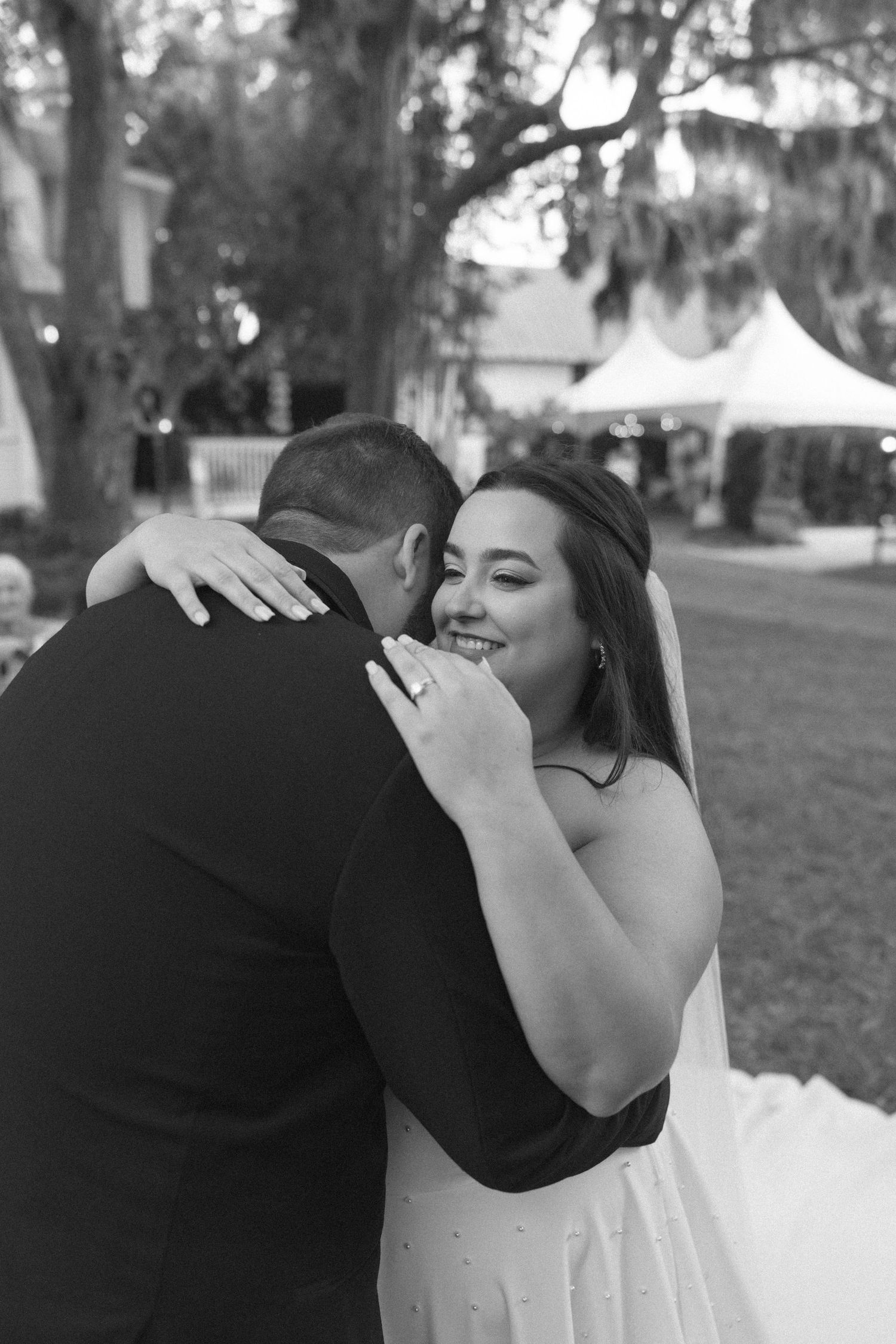 A series of intimate black and white wedding photos showing tender embraces between a couple in formal attire.