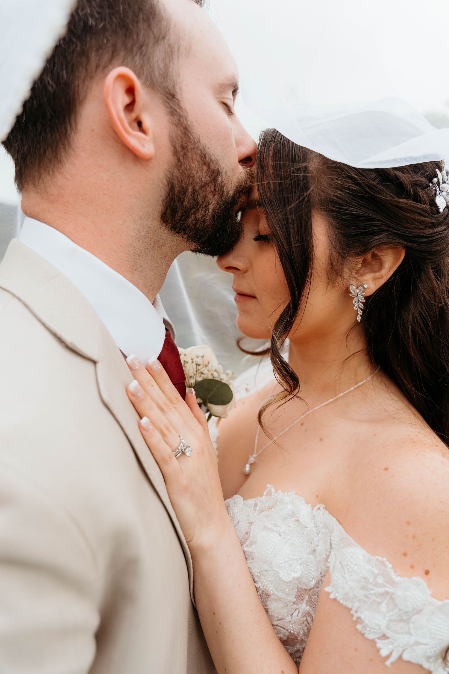 Intimate close-up of couple in formal wedding attire sharing tender moment.