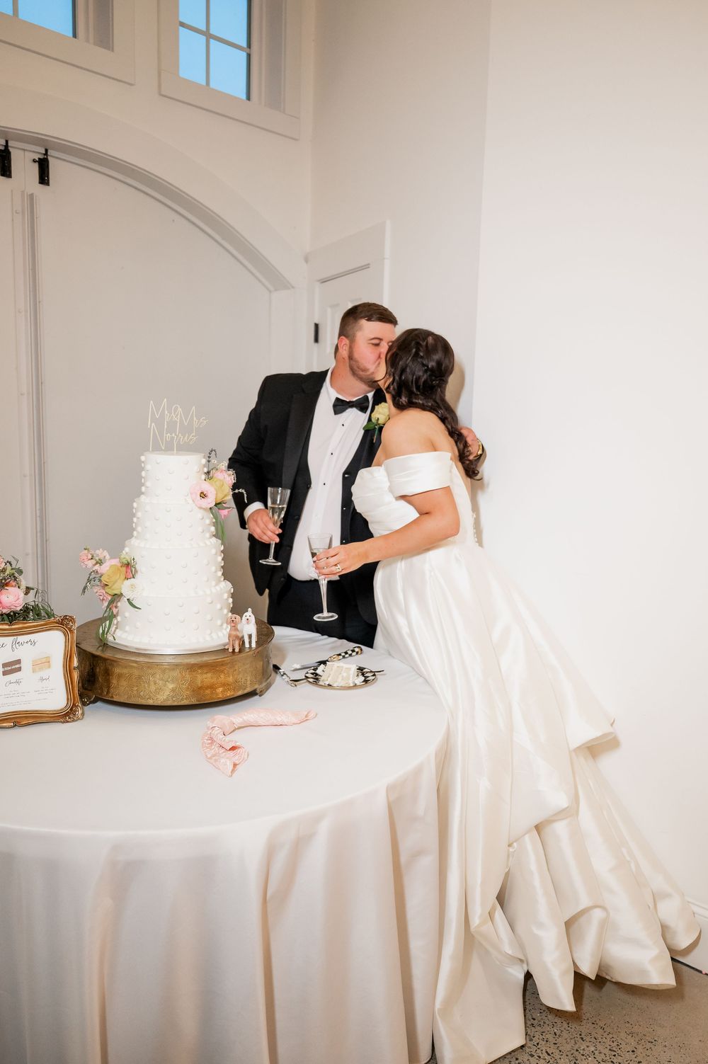 Newlyweds share an intimate moment while cutting their wedding cake at an elegant reception venue.