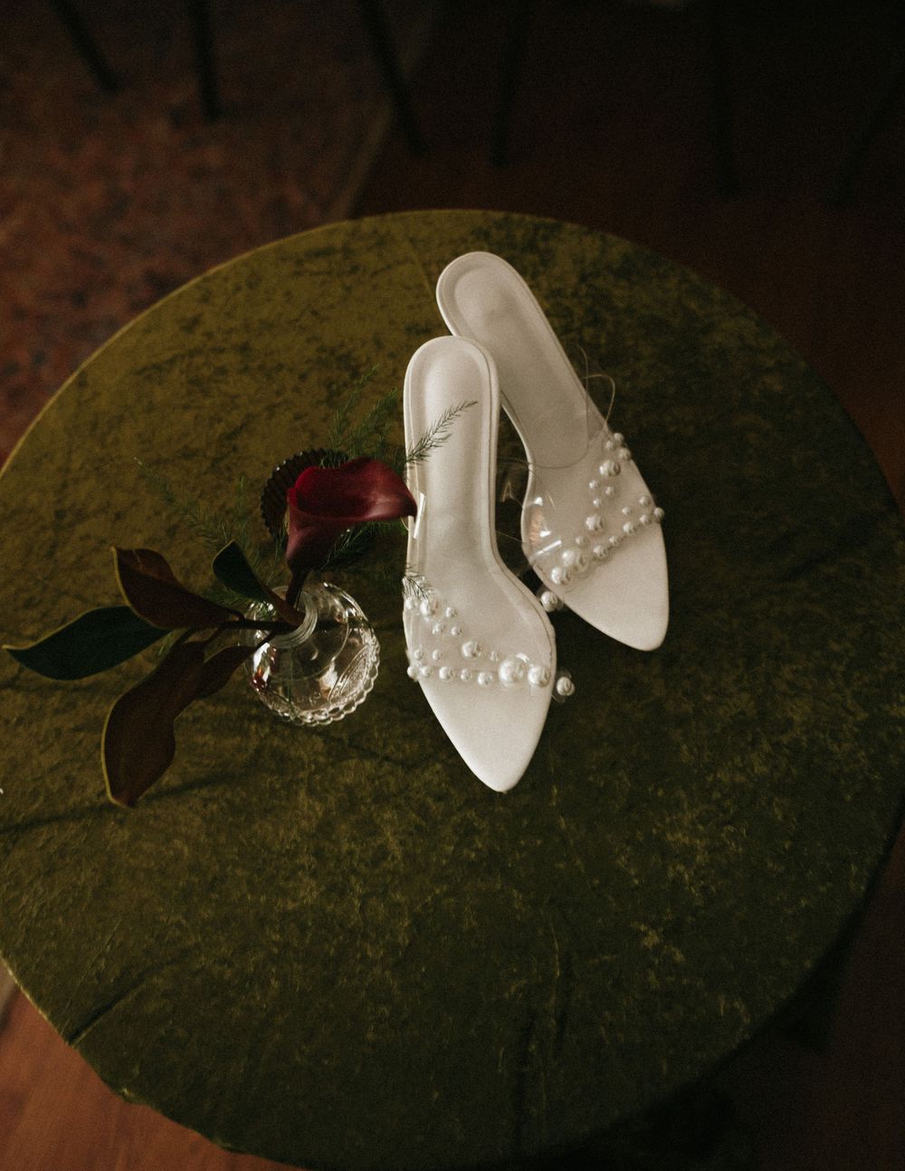 Decorative white butterfly ornaments with pearl details arranged on a dark textured surface.