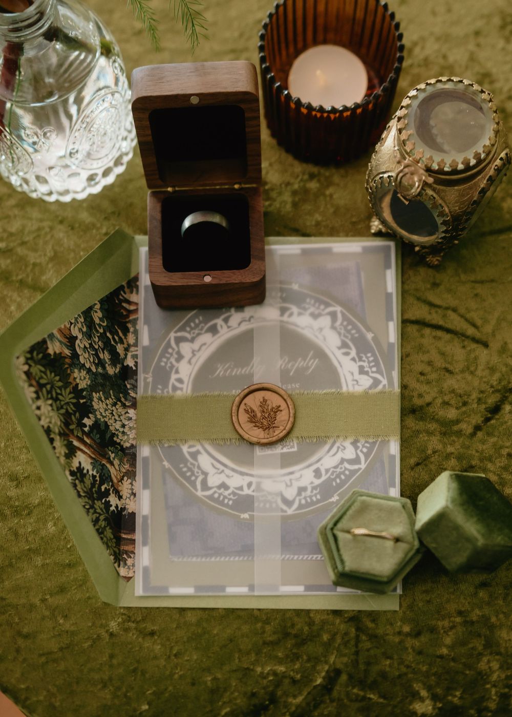 Wedding reception table details with vintage glassware and decorative elements on a textured surface.