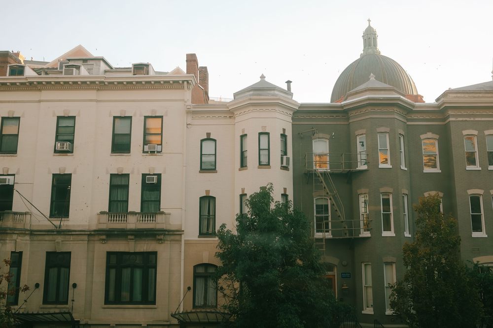 A panoramic view of historic Victorian row houses with ornate architecture and domed features.
