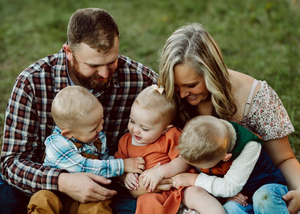 An intimate family moment captured during a casual outdoor photo session.