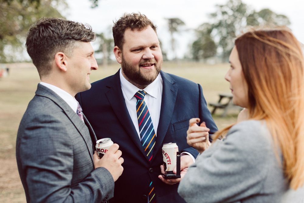 Three guests enjoying drinks and conversation at an outdoor event.