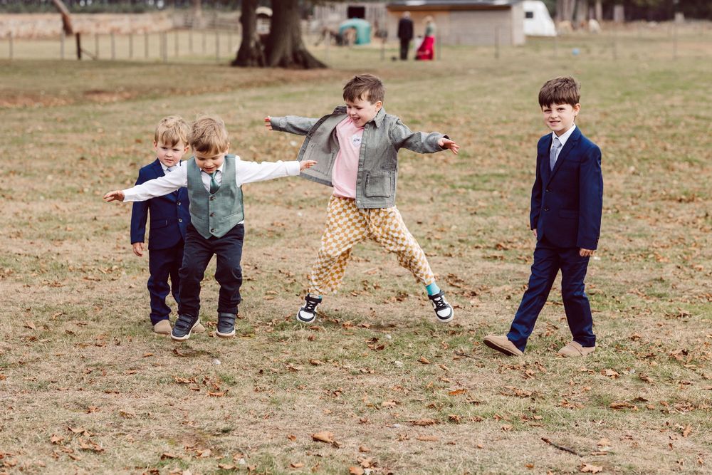 Children playing and running together on a grassy field during outdoor activities.