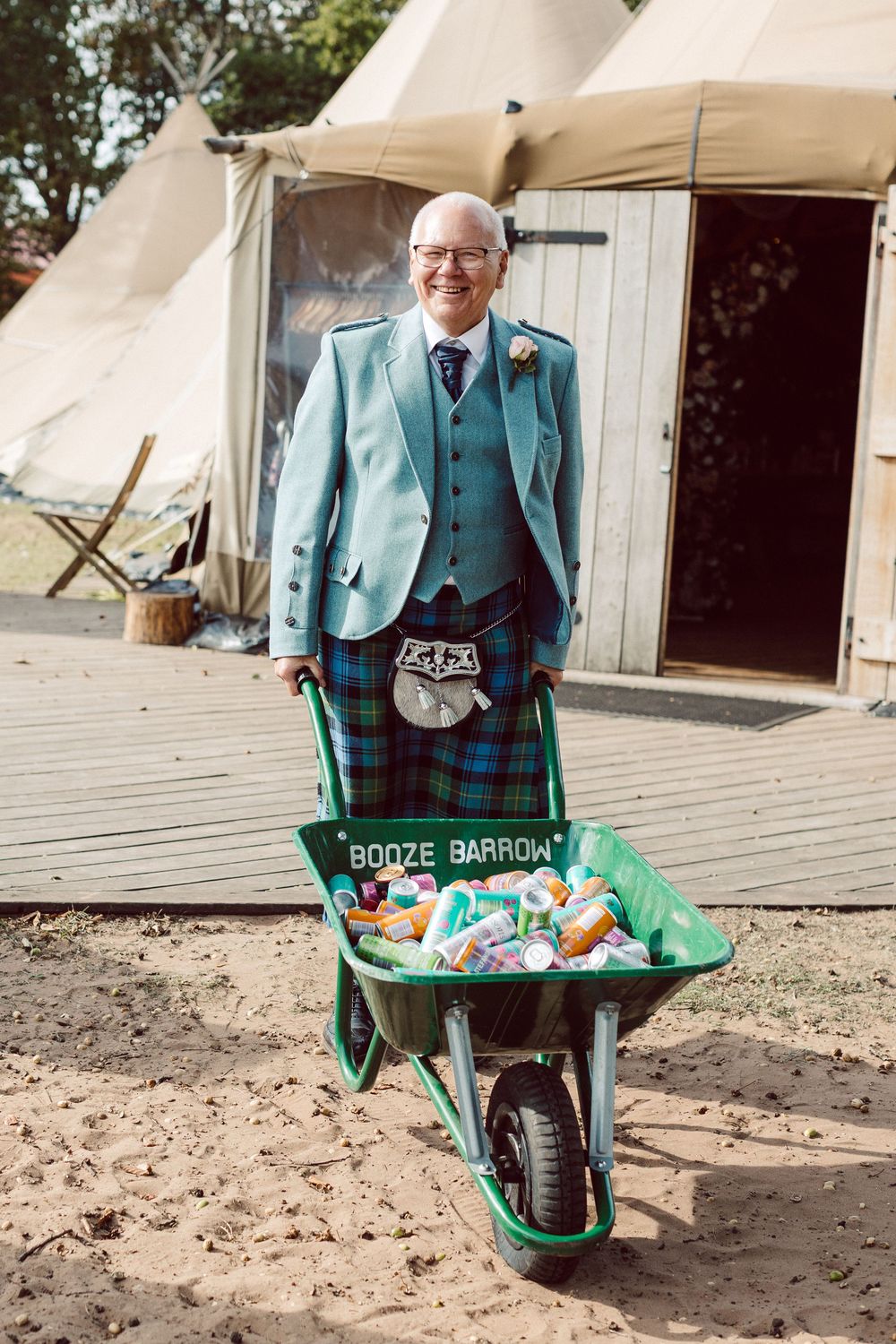 A wheelbarrow filled with beverages and ice serves as a creative drink station at an outdoor event.