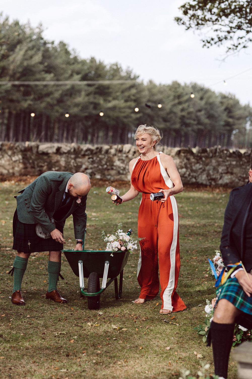 A playful sequence of someone in orange clothing and black clothing playing a game in a grassy outdoor setting.