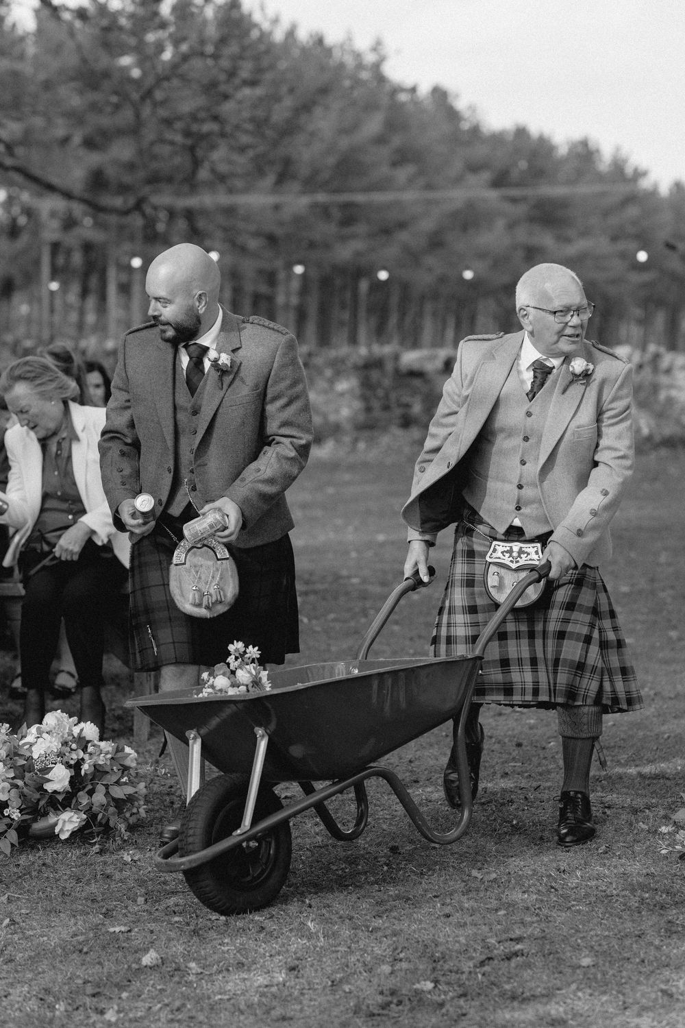 Vintage black and white photograph series showing people planting flowers and gardening with wheelbarrows in a field.