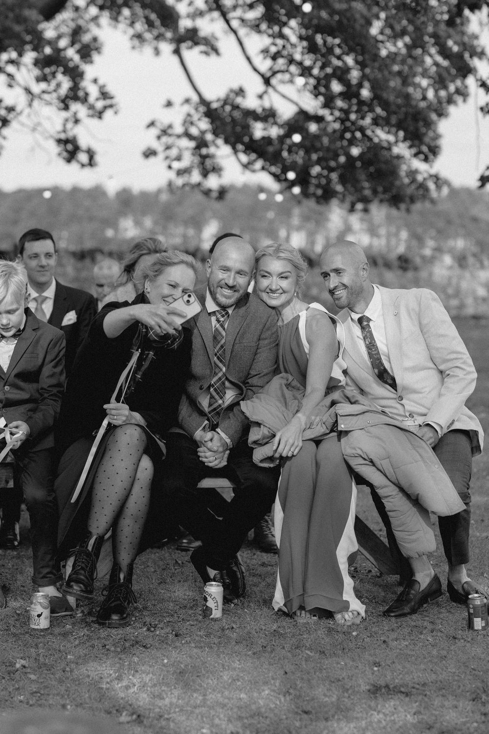 A vintage black and white photograph showing a group of men lounging and reclining on grass outdoors.