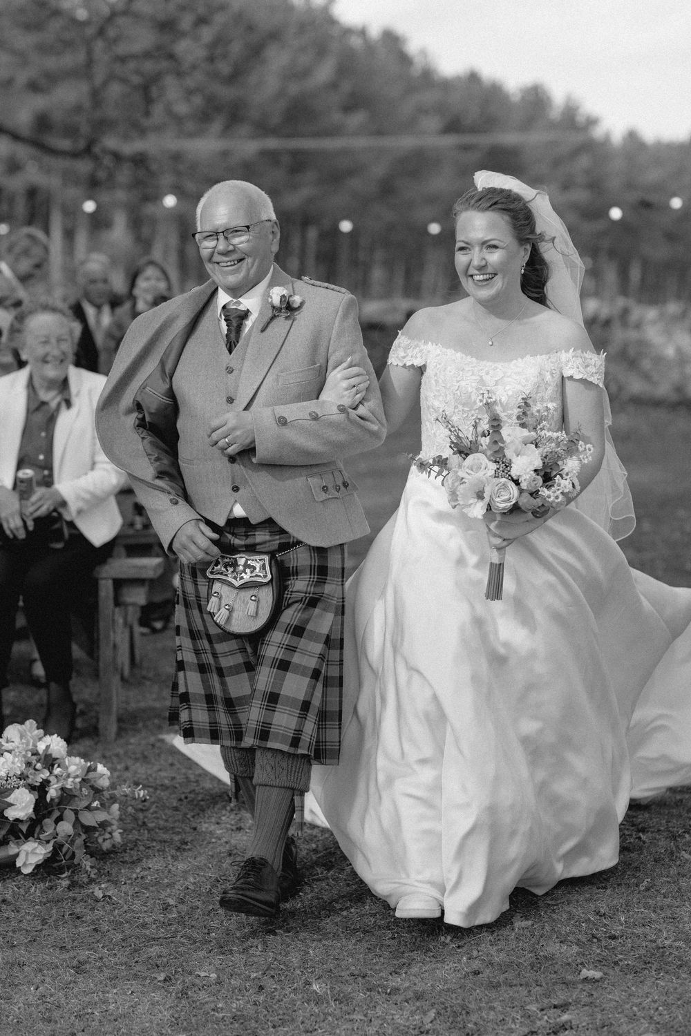 Black and white wedding photos showing candid moments of celebration with guests in traditional Scottish kilts and formal attire.