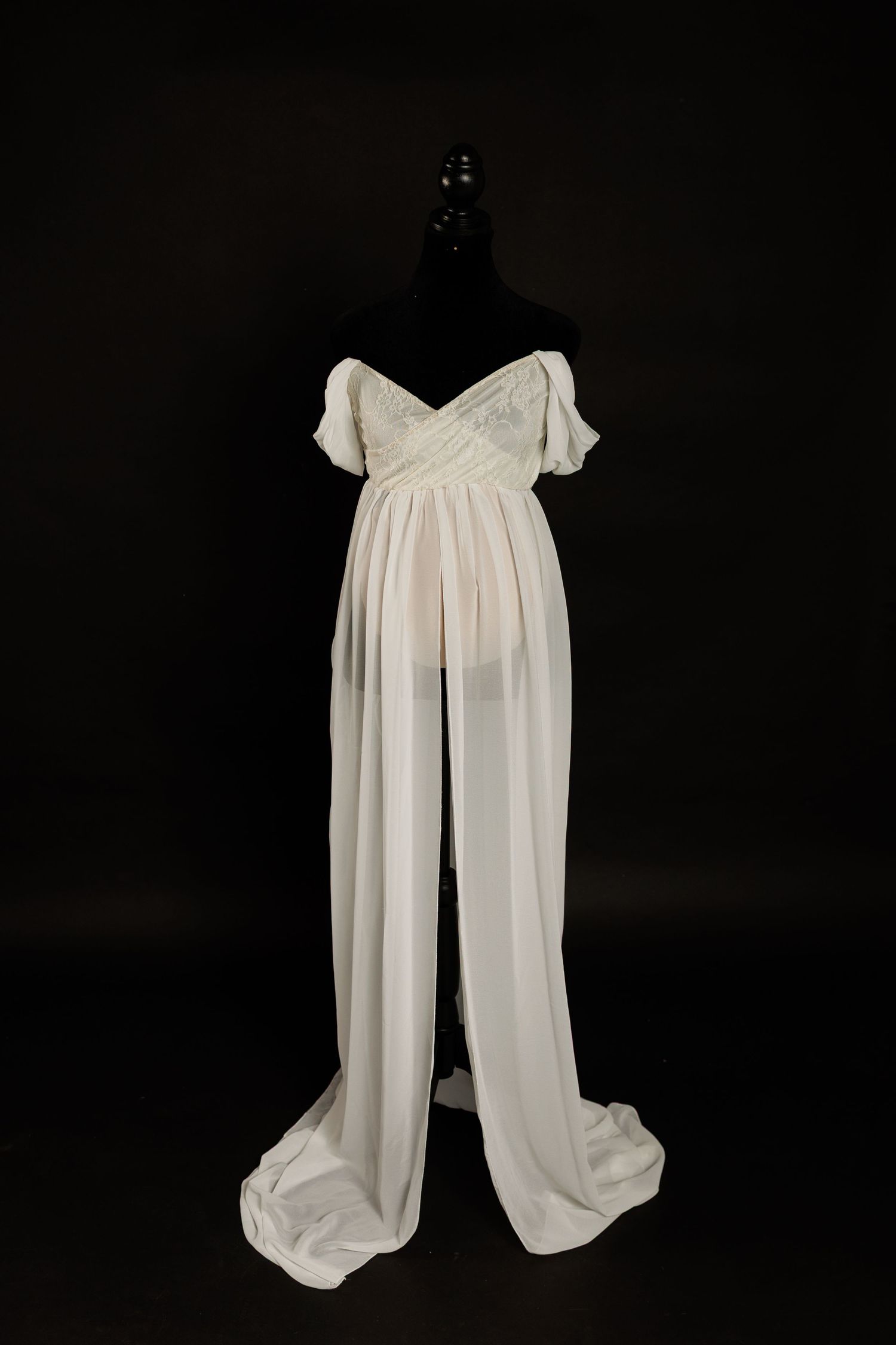 Ivory maternity gown with lace bodice, off-the-shoulder sleeves, empire waist, and split-front chiffon skirt on a dress form.