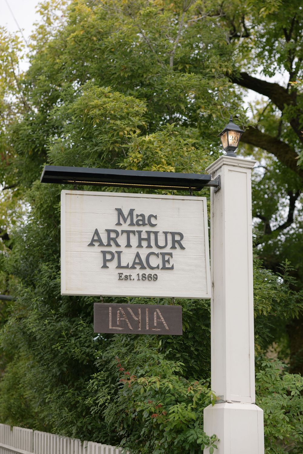 Vintage style signage for Mac Arthur Place established 1869 mounted on white posts.