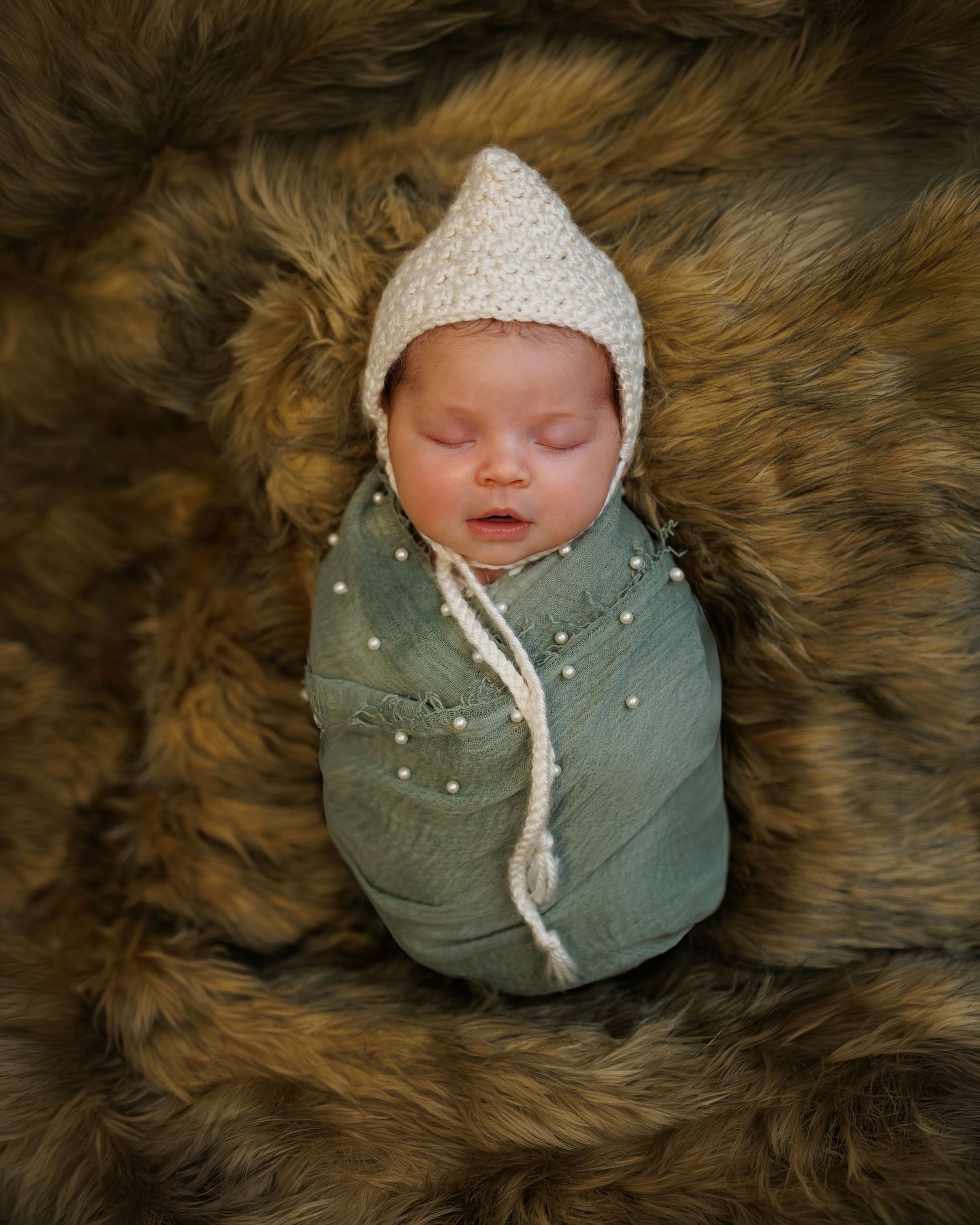 A series of artistic newborn baby portraits on dark blue textured fabric showing close-up details of tiny features.