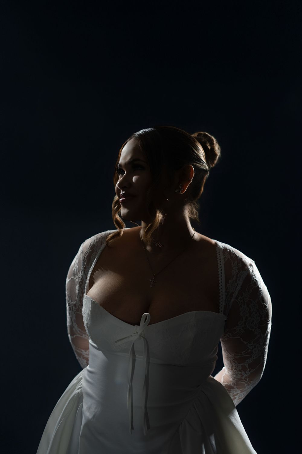 A series of moody portraits showing someone in a white bridal gown against a dark background.