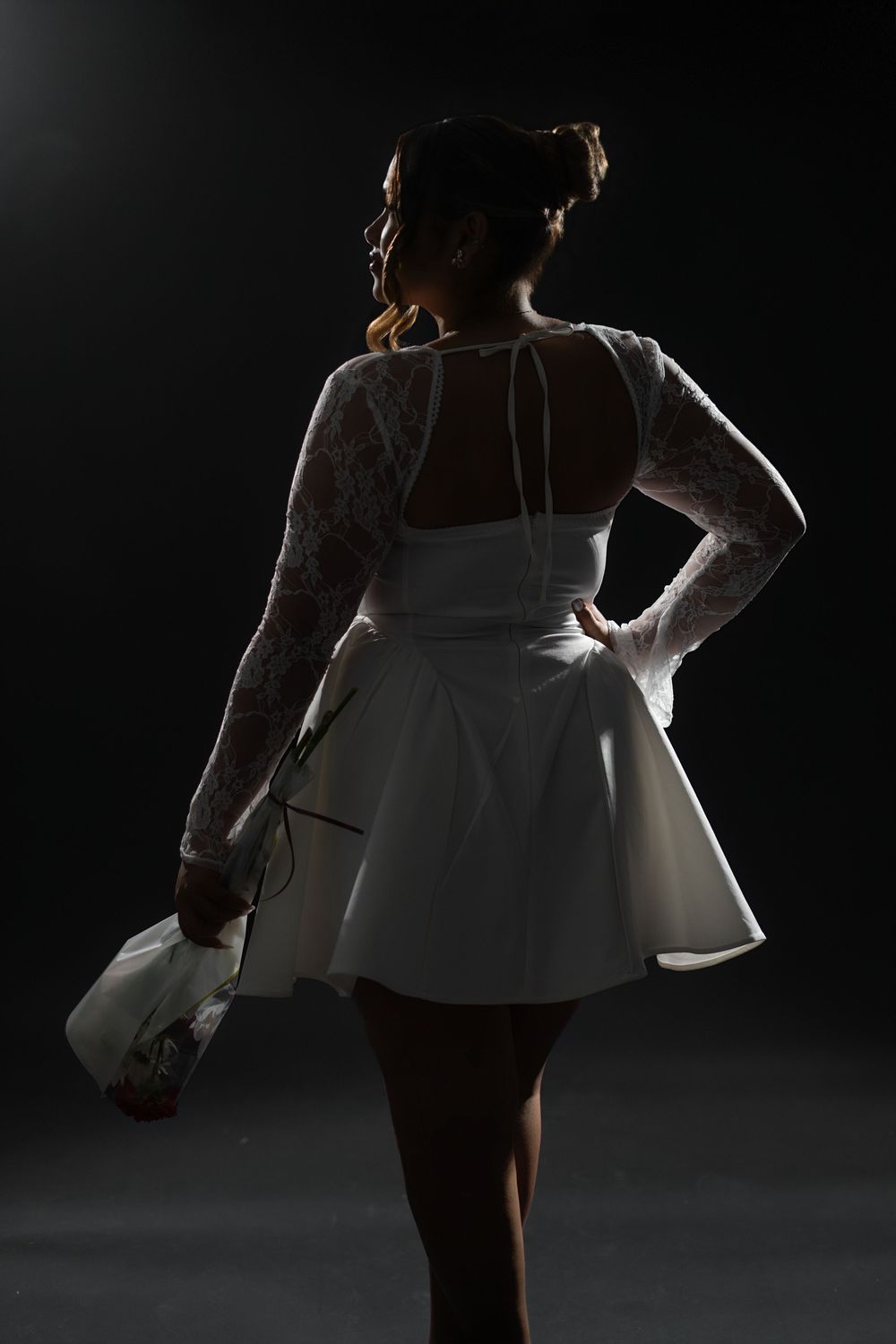 A series of dark and dramatic photographs showing a dancer in a white dress performing expressive movements against a black background.