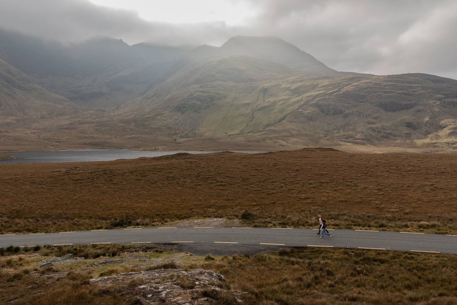 couple running through Doolough valley during their adventure engagement session