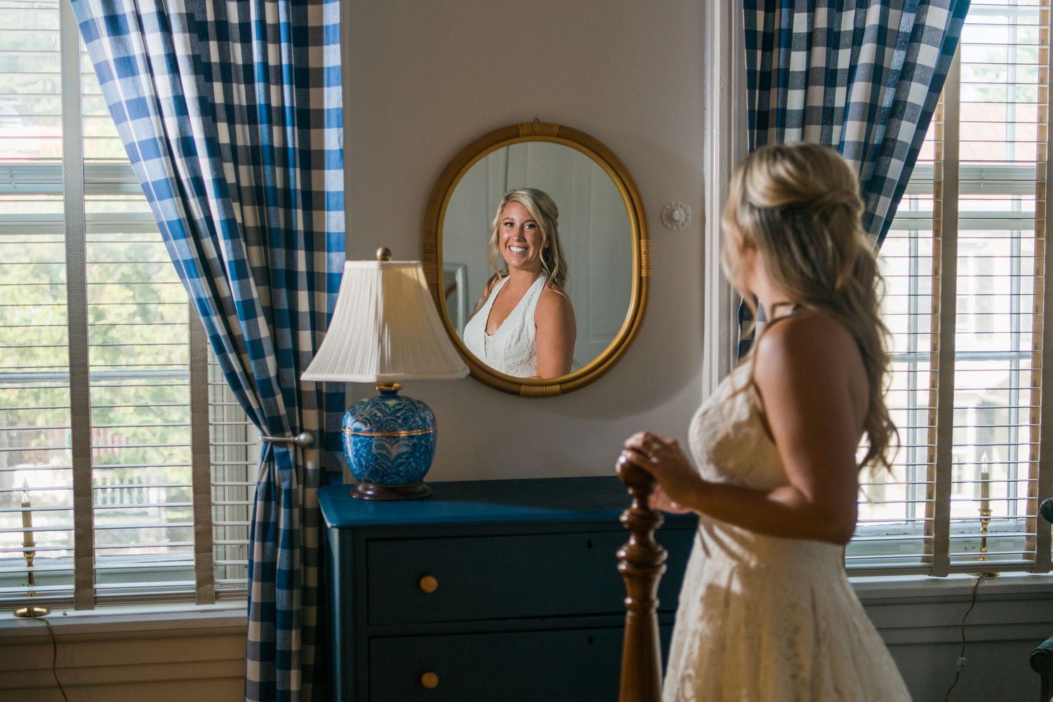 Interior room with blue checkered curtains and sunlight streaming through windows.