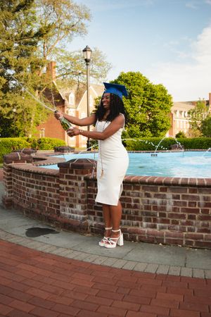 A series of photos showing someone in a white dress posing along a brick wall on a sunny day.