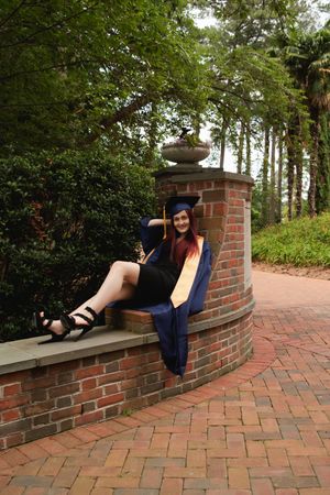 A series of photos showing a person in dark clothing and heels lying on a curved brick wall in an outdoor garden setting.