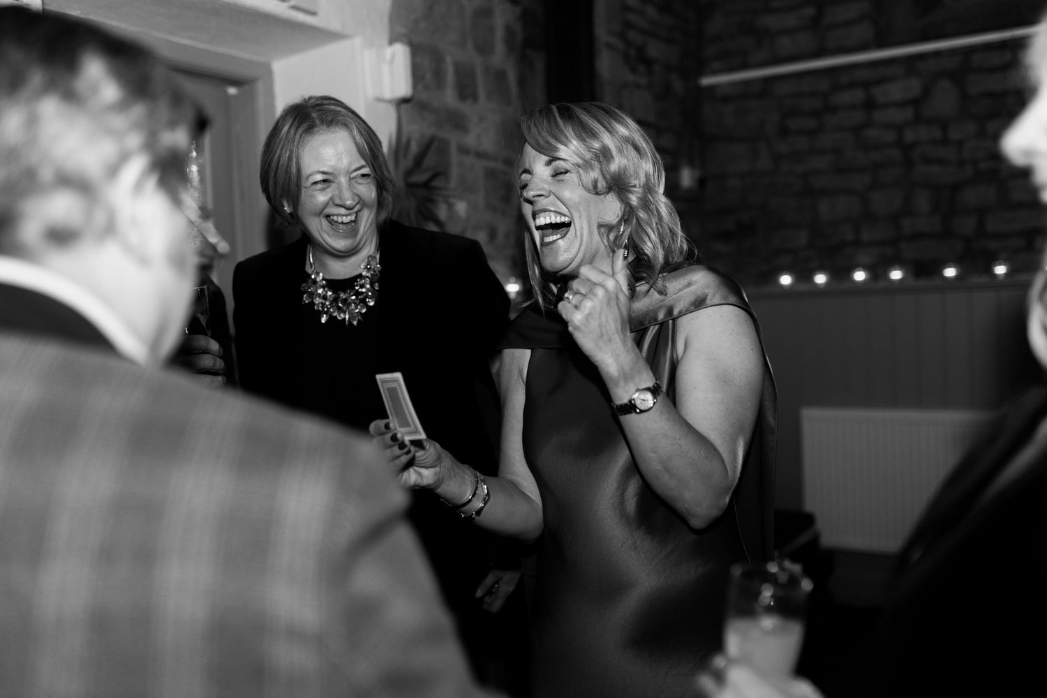 A series of black and white candid photos showing people laughing and enjoying themselves at what appears to be a party.