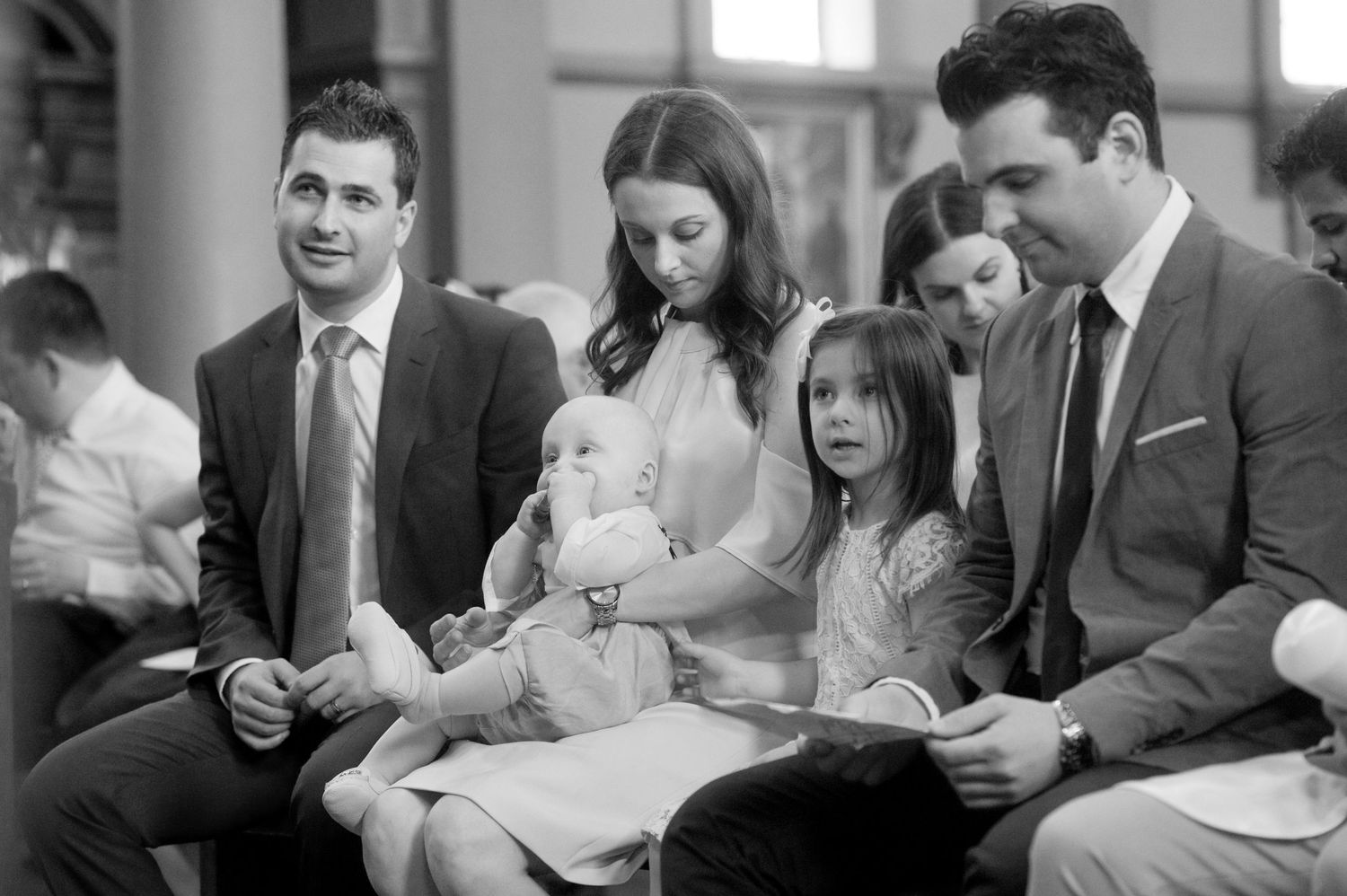 Family participates in baptism ceremony inside historic church sanctuary.