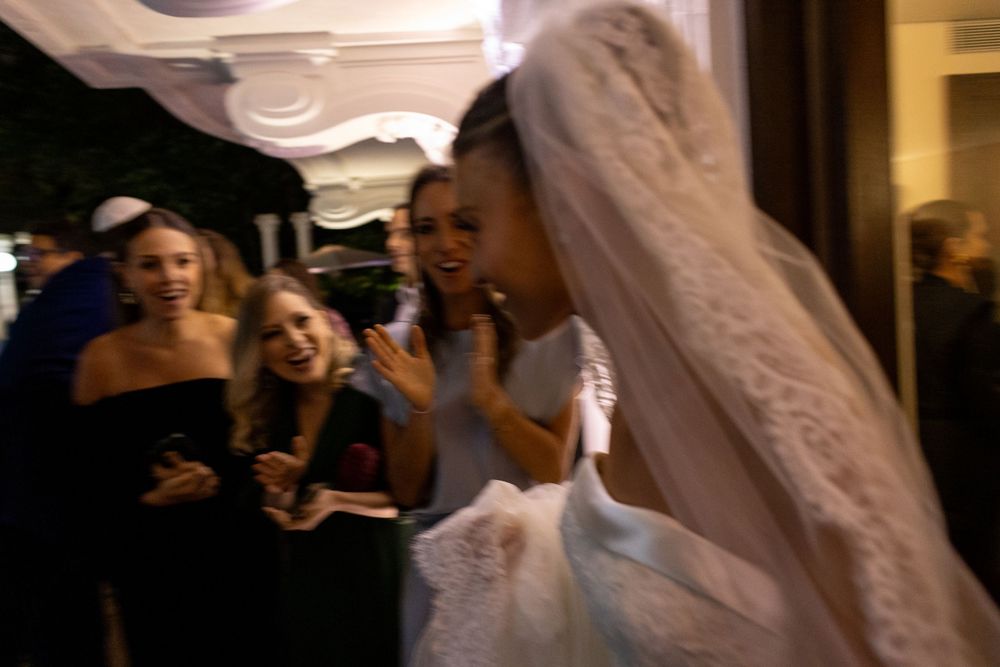 Elegant white wedding dress with intricate lace details and flowing veil.
