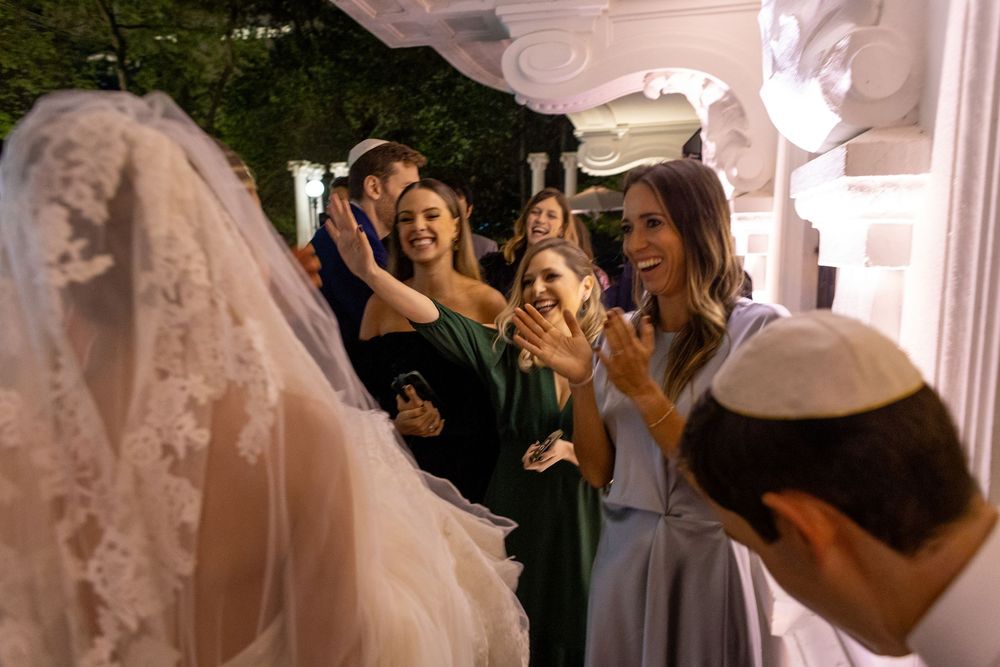 A wedding celebration with guests dancing and celebrating in an elegant indoor venue.