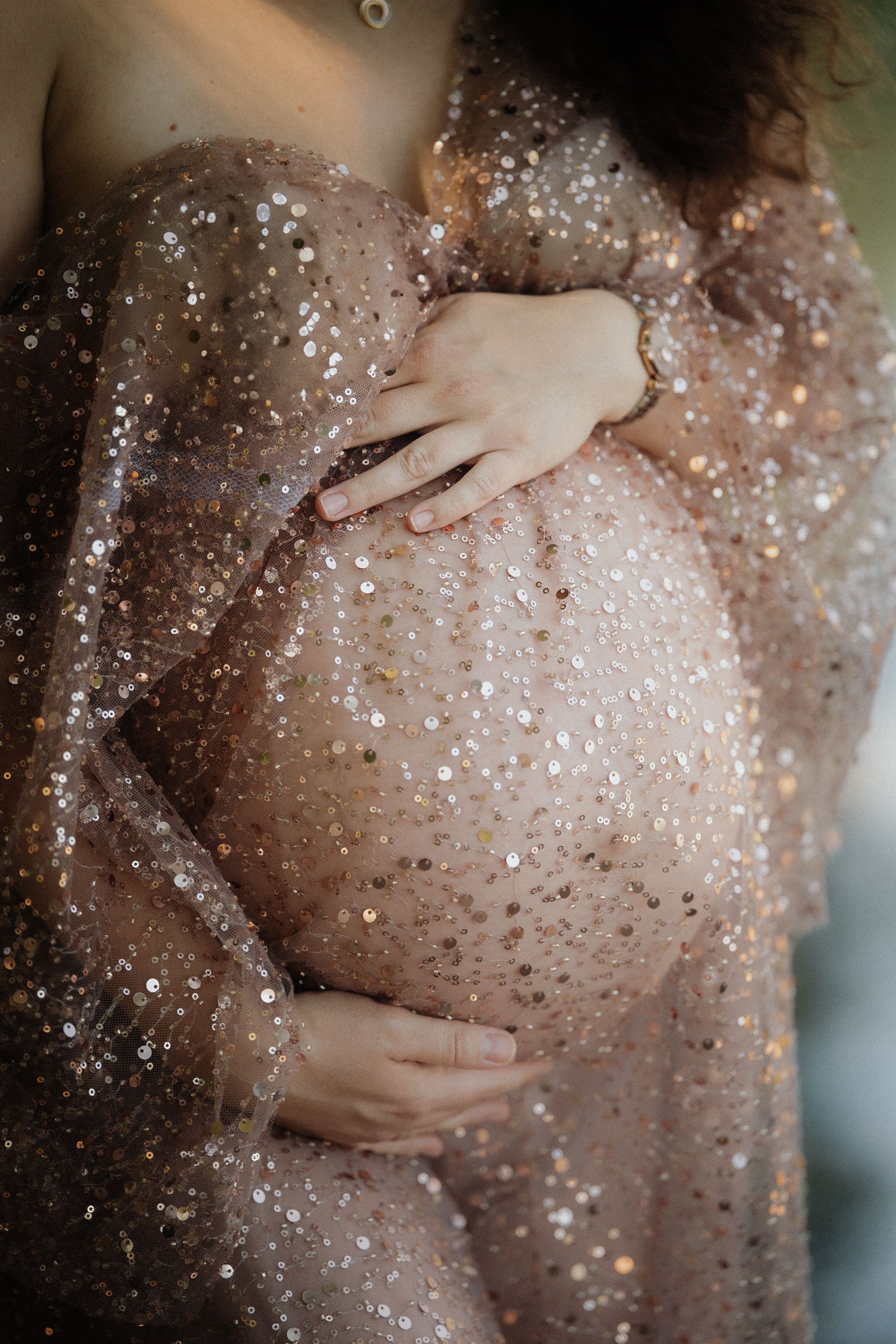 Artistic maternity photography sequence showing a pregnant belly covered in glitter and sparkles with gentle hands caressing.