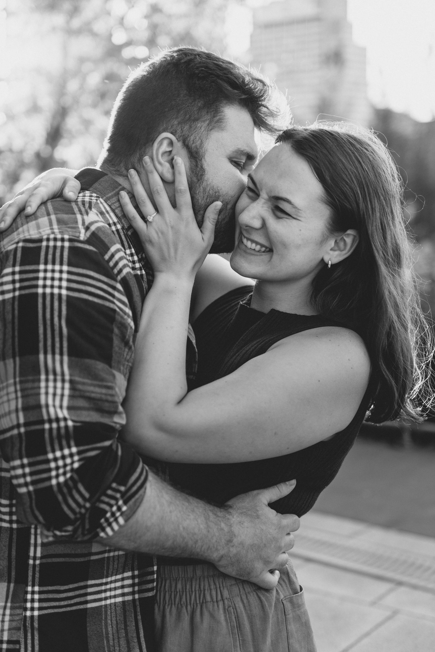 A couple embraces in a series of black and white photos showing affection and joy.