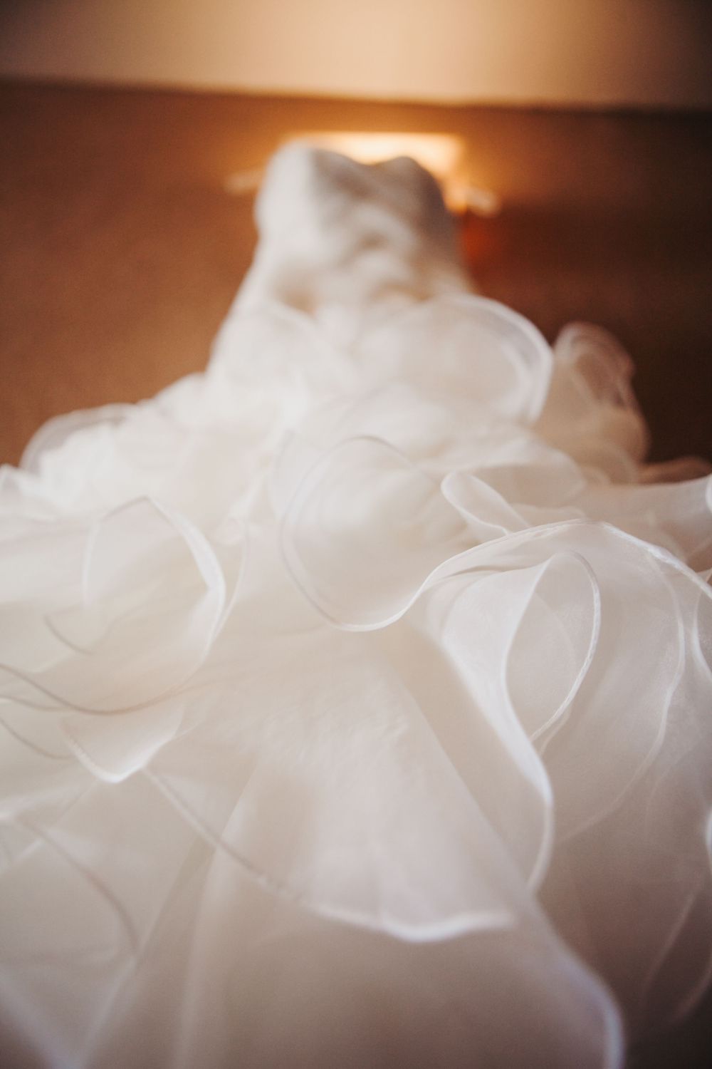 Ethereal white fabric with delicate folds creates a soft, dreamy texture in warm lighting.