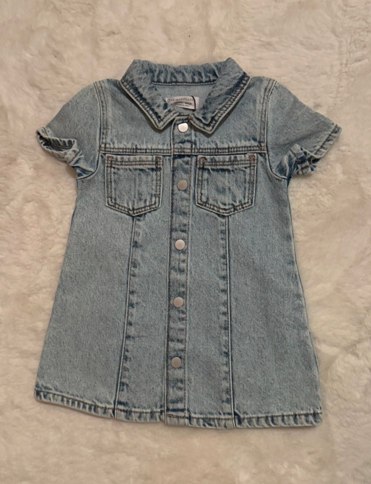 Cropped light blue denim vest with button front closure and collar.