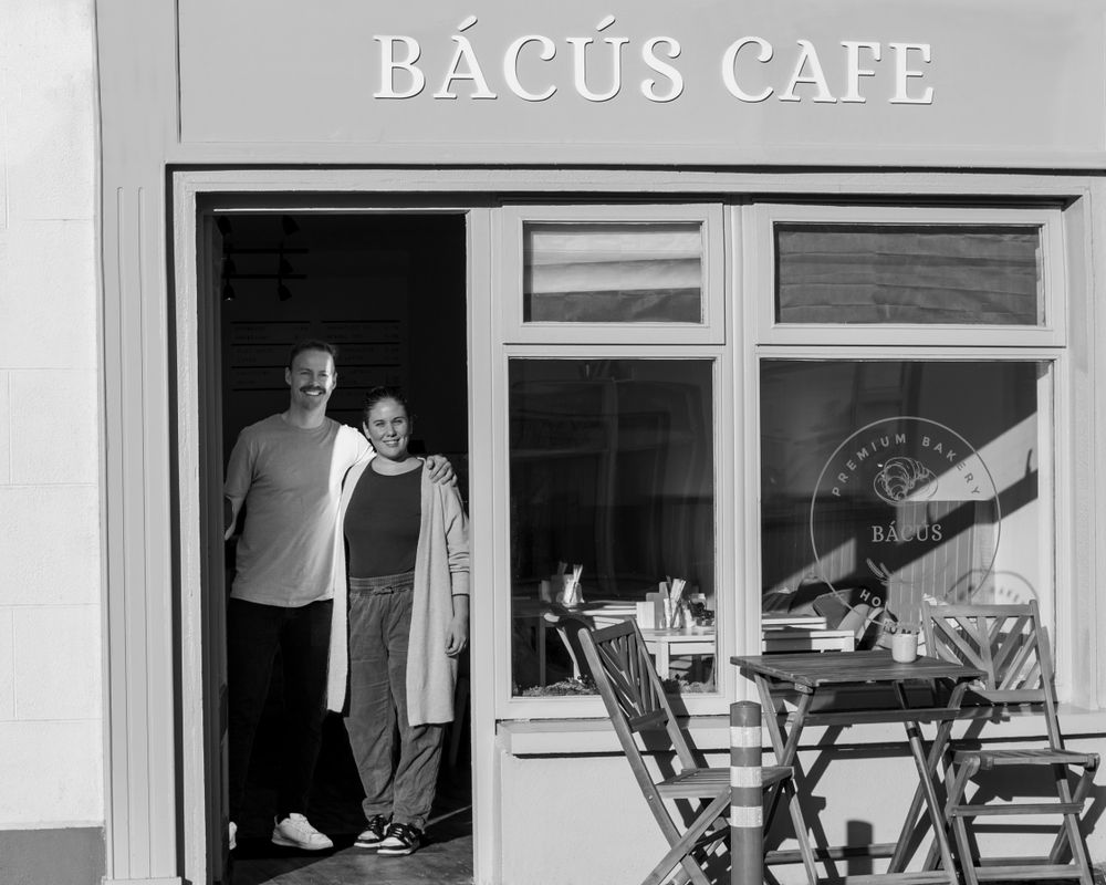 Exterior view of Bacus Cafe with outdoor seating and windows.
