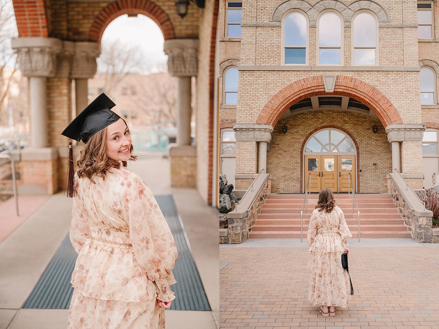Graduate wearing floral dress and cap poses in front of historic brick university building entrance.