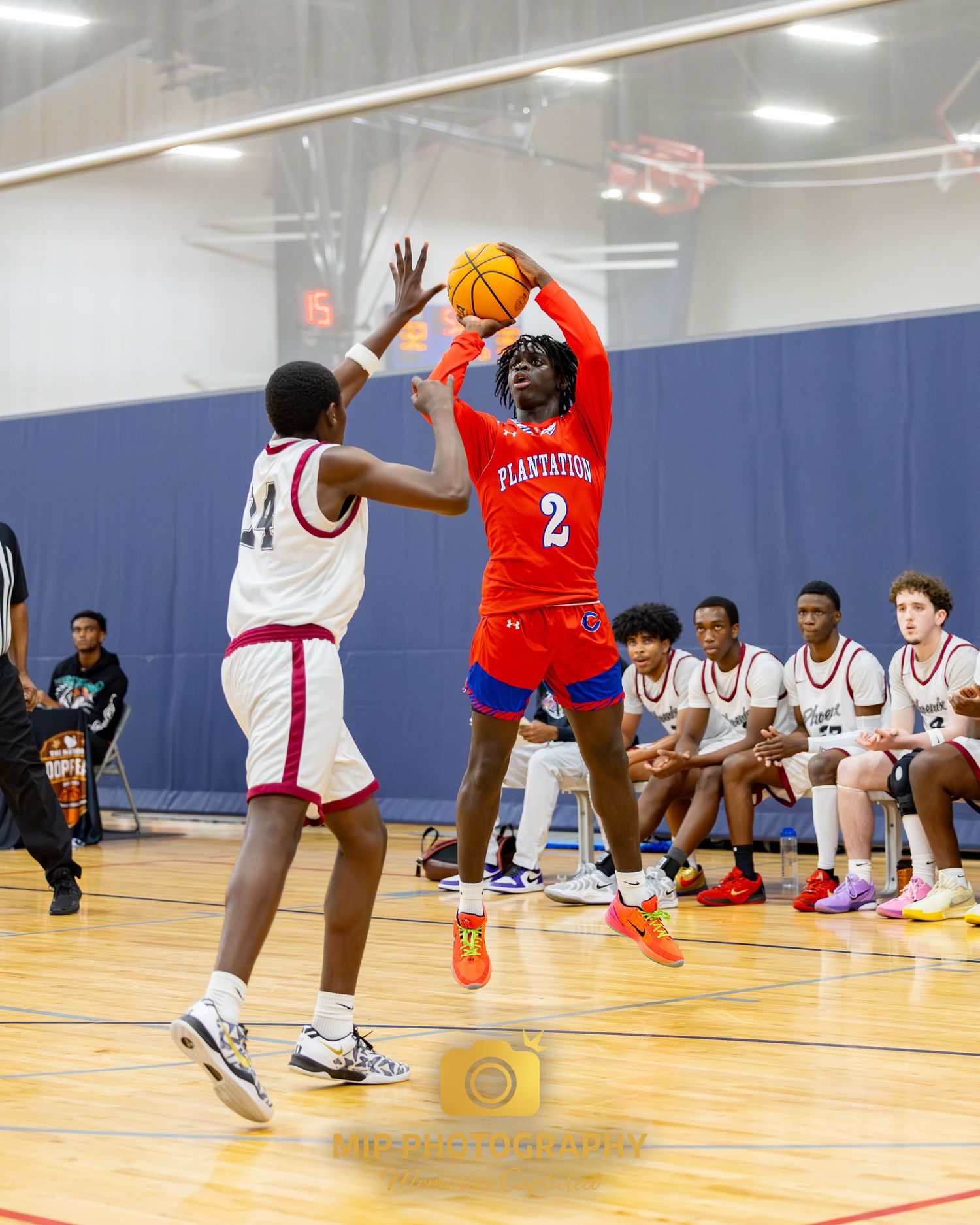 Basketball players from opposing teams compete for a shot during an indoor game.