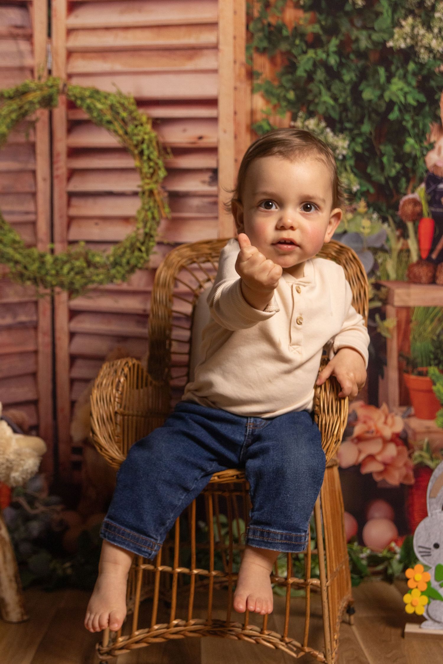 A series of photos showing a toddler in blue jeans and beige shirt sitting on a wicker chair against a rustic backdrop.