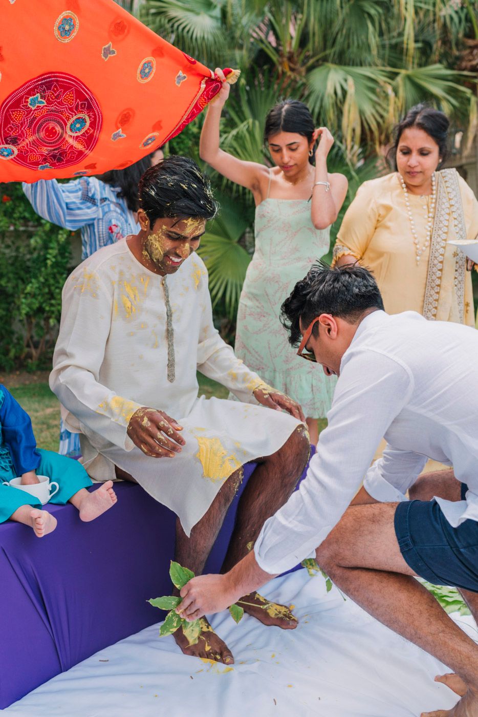 Traditional Indian pre-wedding haldi ceremony preparation taking place in an outdoor garden setting.