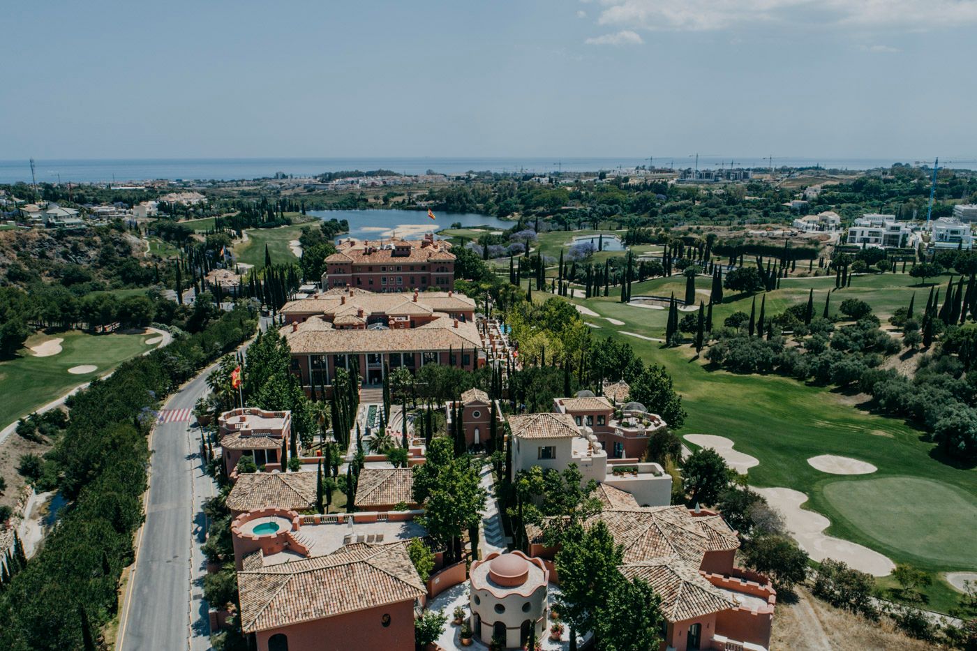 Aerial view of luxury Mediterranean-style villas and a golf course along the coastline.