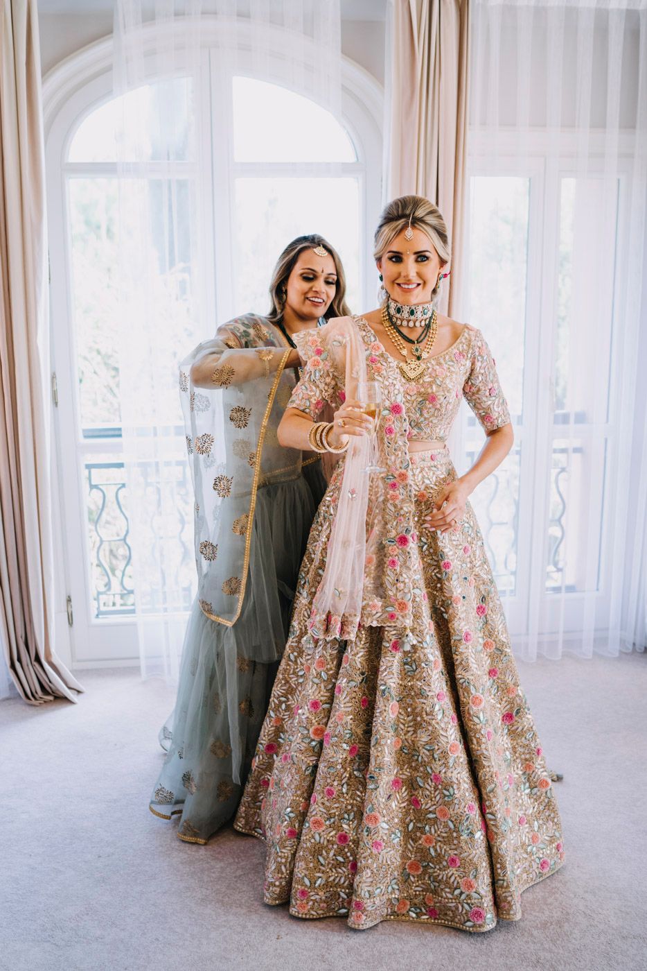 Beautiful floral embroidered lehenga with intricate details photographed in an elegant room with sheer curtained windows.