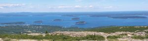 Aerial panorama of coastal islands and blue ocean waters viewed from mountain summit.