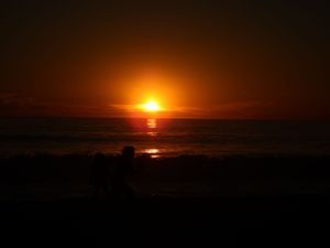 Series of orange sunset images showing sun descending over dark landscape.