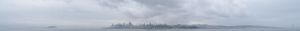 Wide cityscape view with cloudy gray skies over urban skyline.