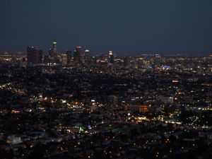Aerial view of a sprawling city skyline at night with twinkling lights stretching to the horizon.