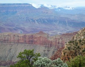 Panoramic view of red rock formations and canyons stretching across desert landscape.