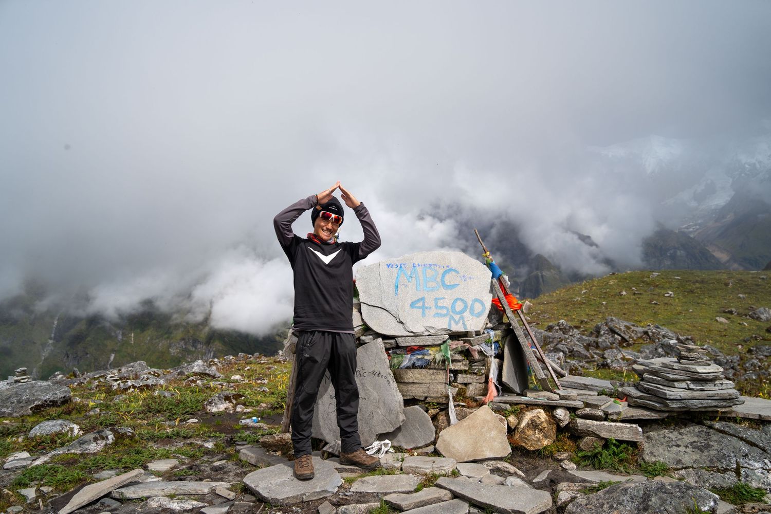 Mountaineers exploring a rocky alpine landscape with distant peaks emerging through clouds.