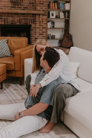 a couple embraces on their couch in their home with cozy warm lighting