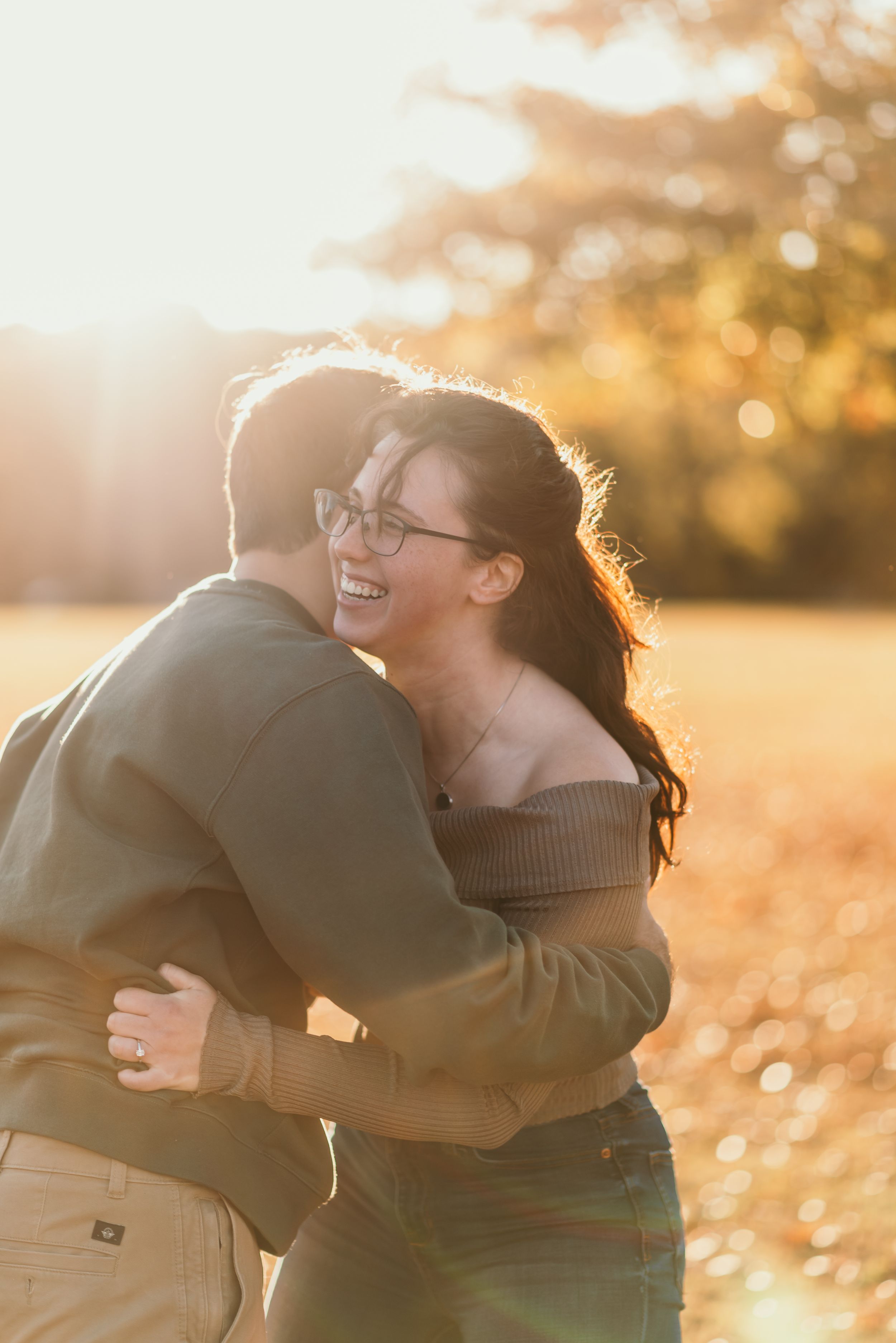 a couple embraces each other in golden hour light in autumn in virginia.