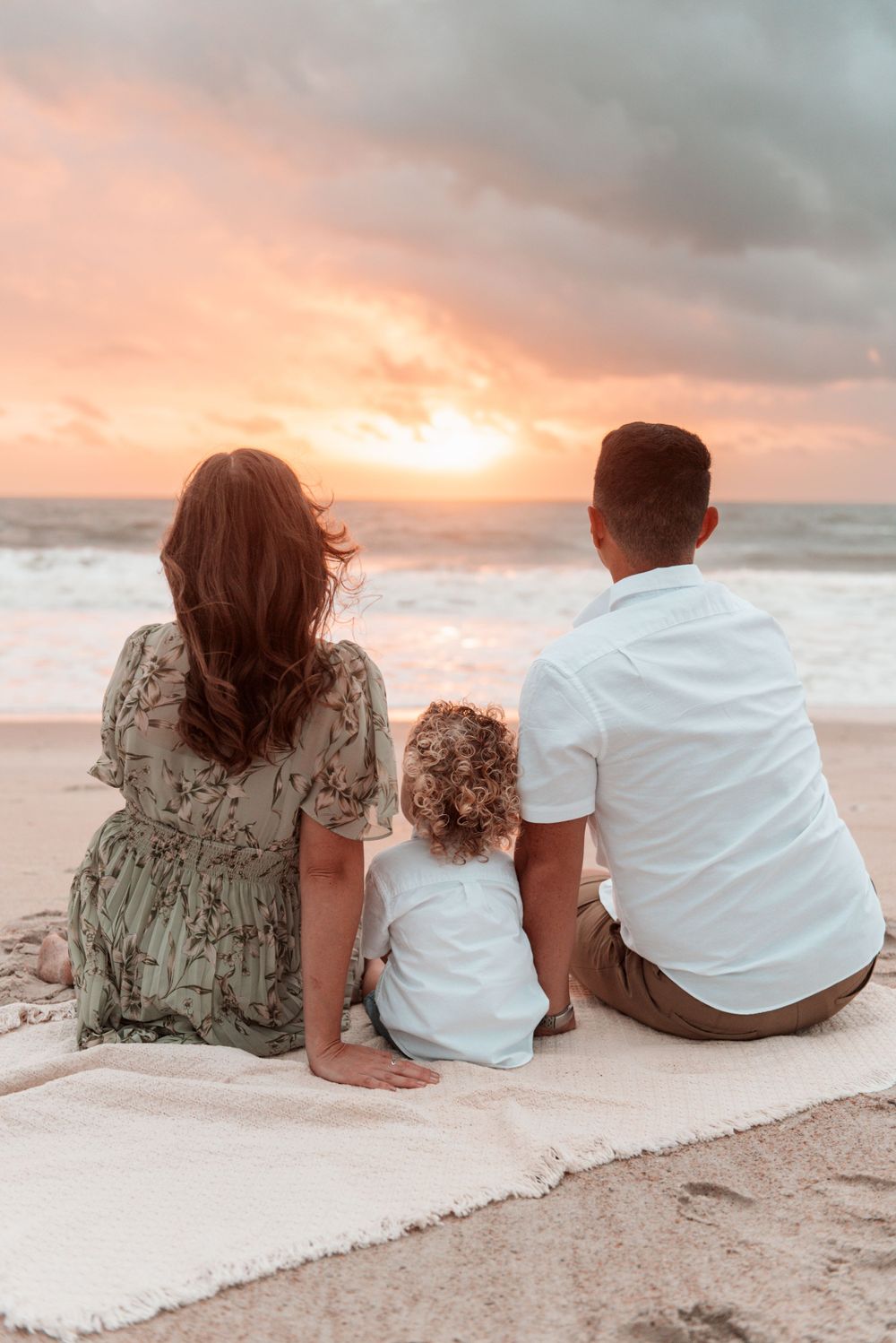 A military family embraces at the beach at golden hour in Jacksonville, Florida.