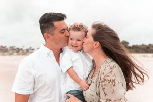 A military family embraces at the beach at golden hour in Jacksonville, Florida.